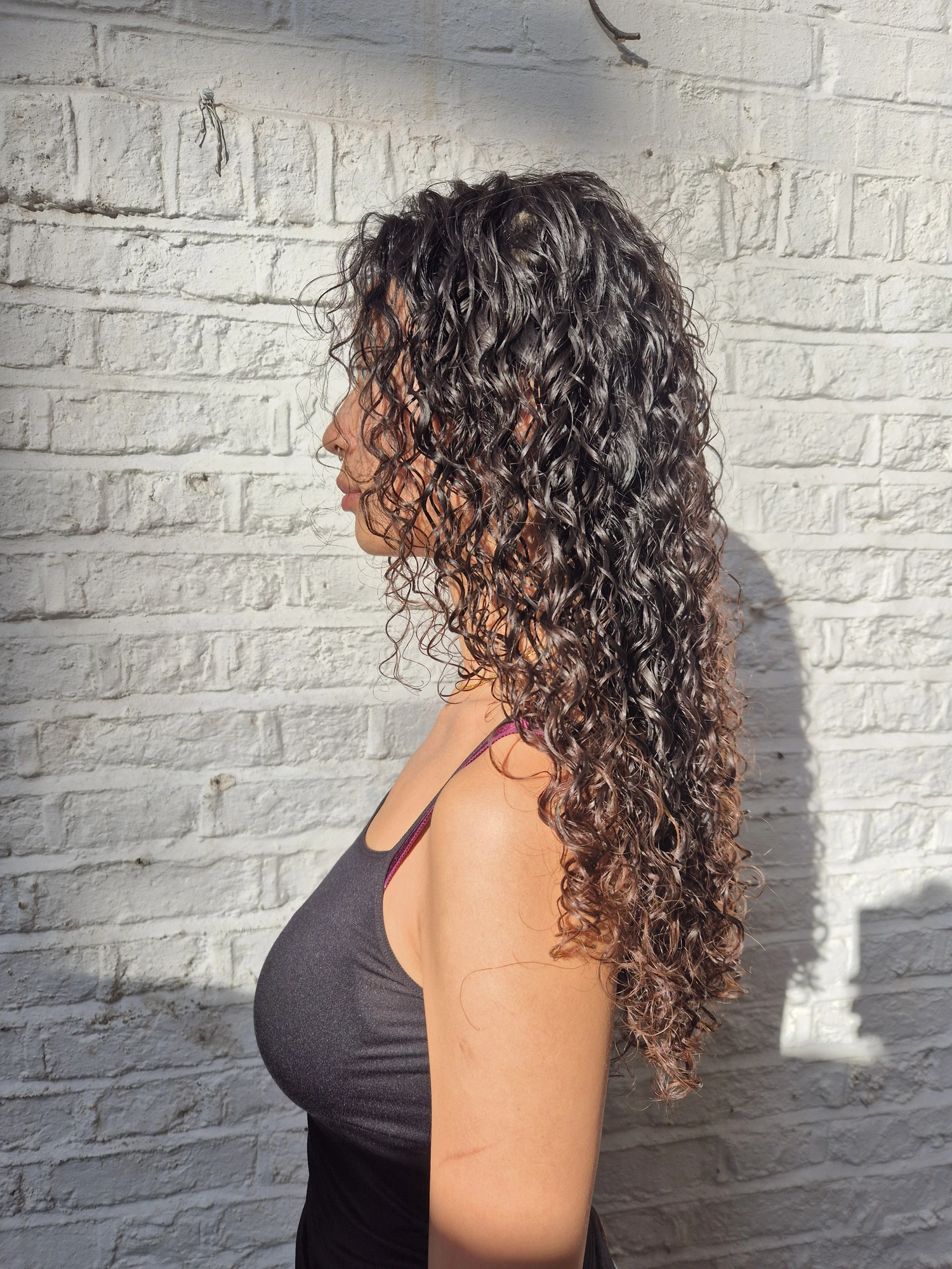 Long dark curly hair photographed from the side