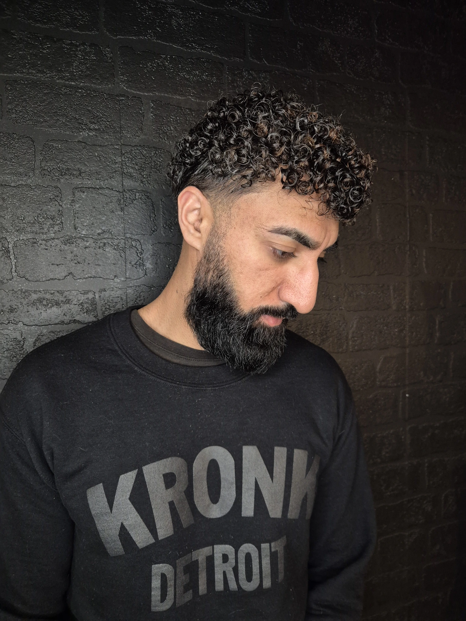 Men's short curly hairstyle with a tapered cut