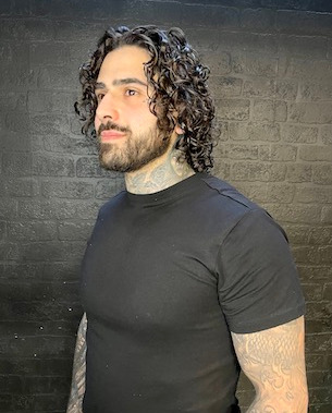 male model with long curly hair and beard