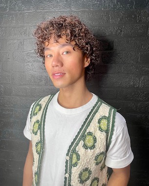 male model with curly hair over ears
